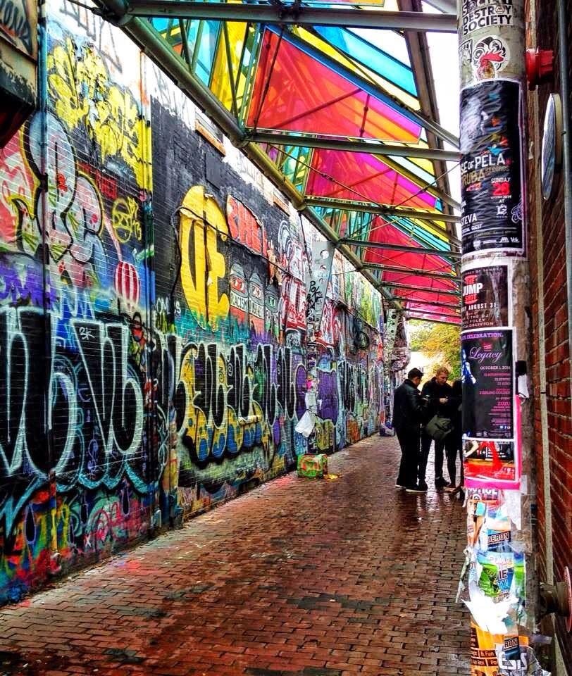 covered walking path with graffiti walls